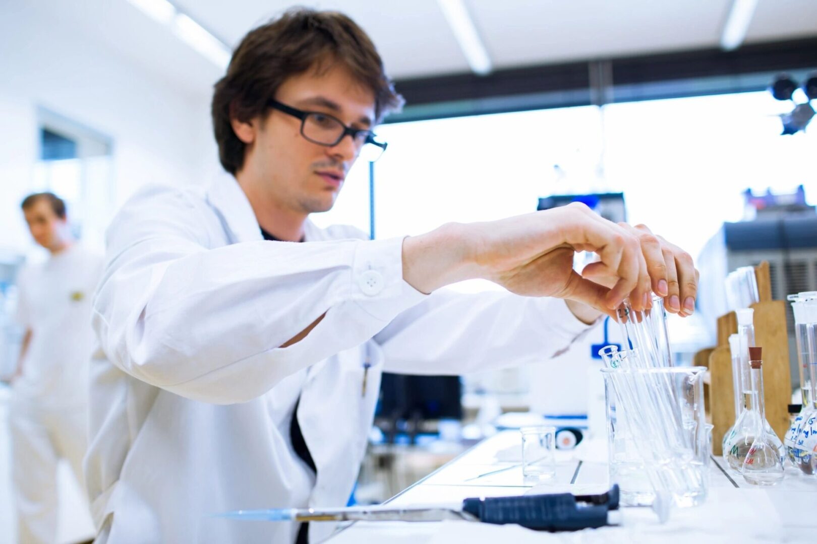 qtq80-MSJzZb Scientist holding test tubes in lab.